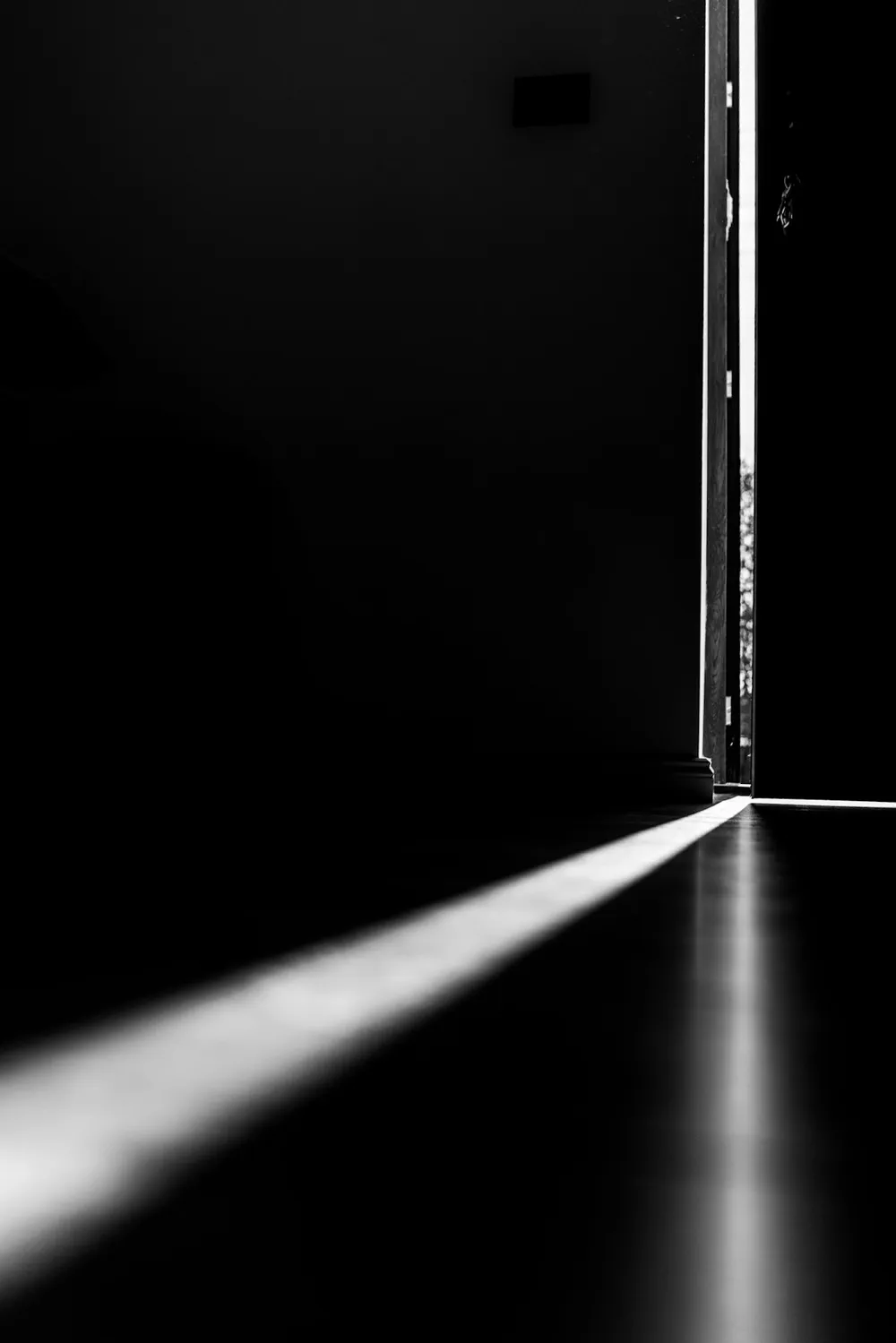 A sliver of light beneath a cracked-open door